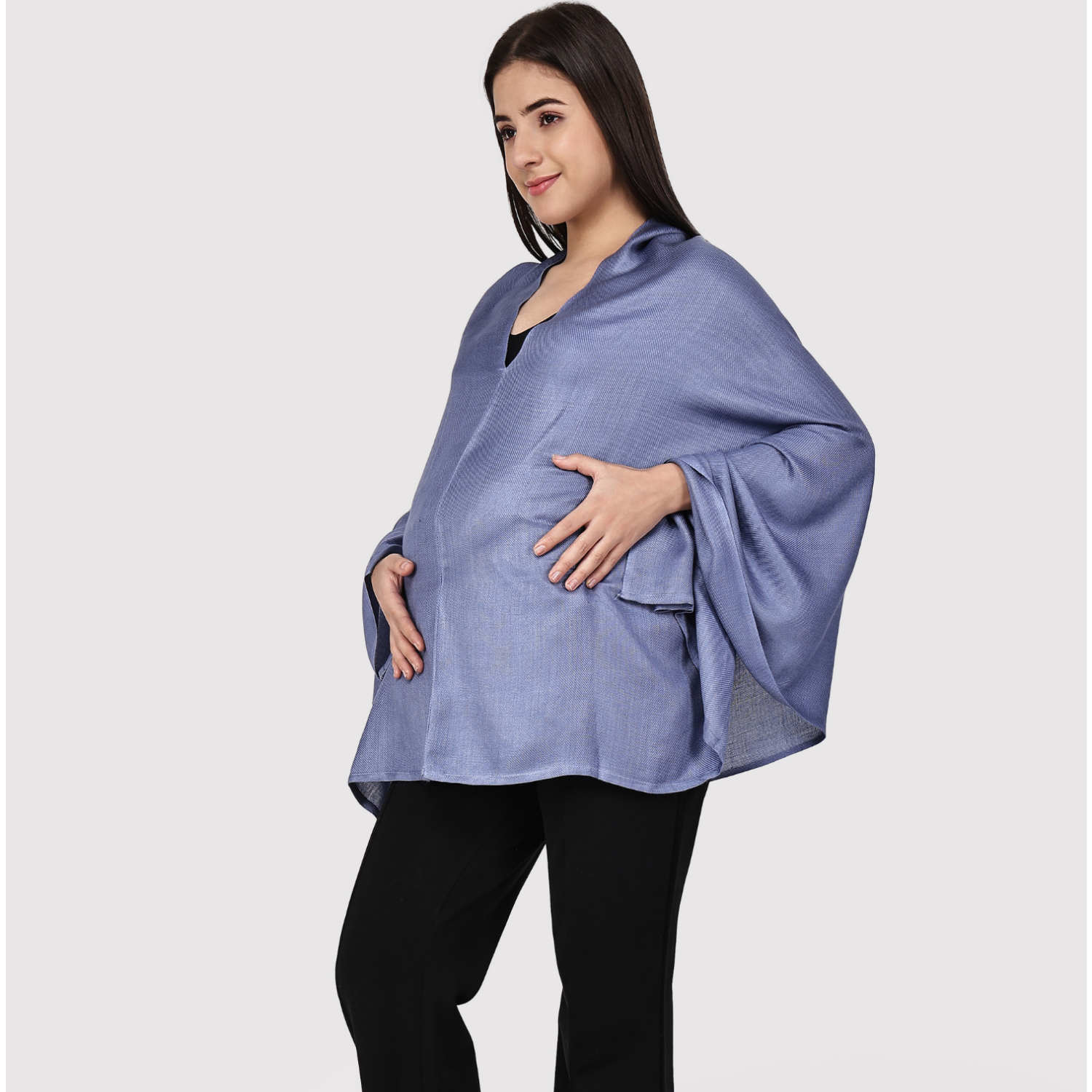 Woman wearing a light blue feeding cover over a black outfit on a white background