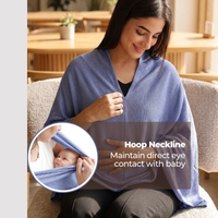 Woman wearing a blue poncho  feeding cover with hoop neckline, sitting on a couch in a home setting.